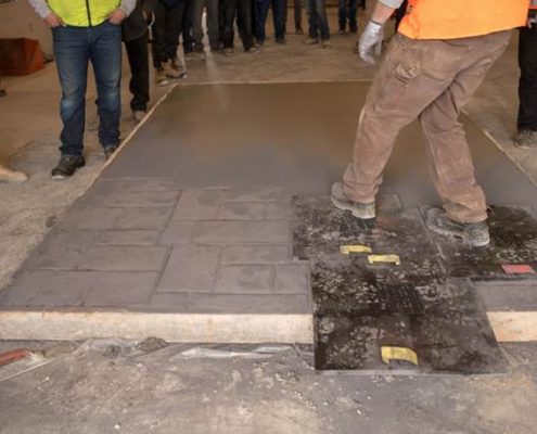 Dufferin concrete employee demonstrating Stamped Concrete on a sample concrete slab